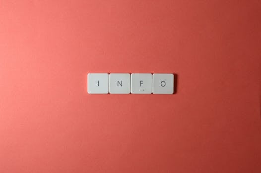 Close-up of keyboard buttons spelling 'INFO' on a minimal red background, ideal for tech and communication themes.